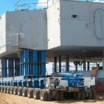 Self-propelled modular trailers (SPMTs) transporting a dragline assembly for the mining industry.
